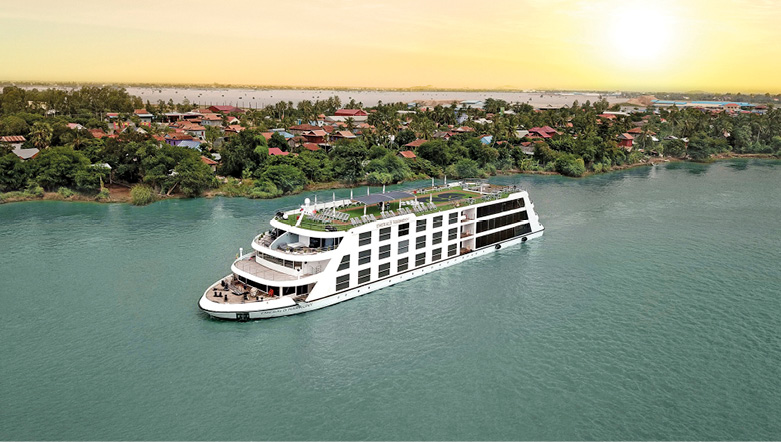 Emerald Harmony sailing past villages along the Mekong