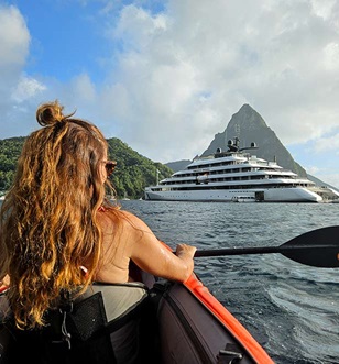 girl on kayak in st lucia with emerald sakar yacht in background
