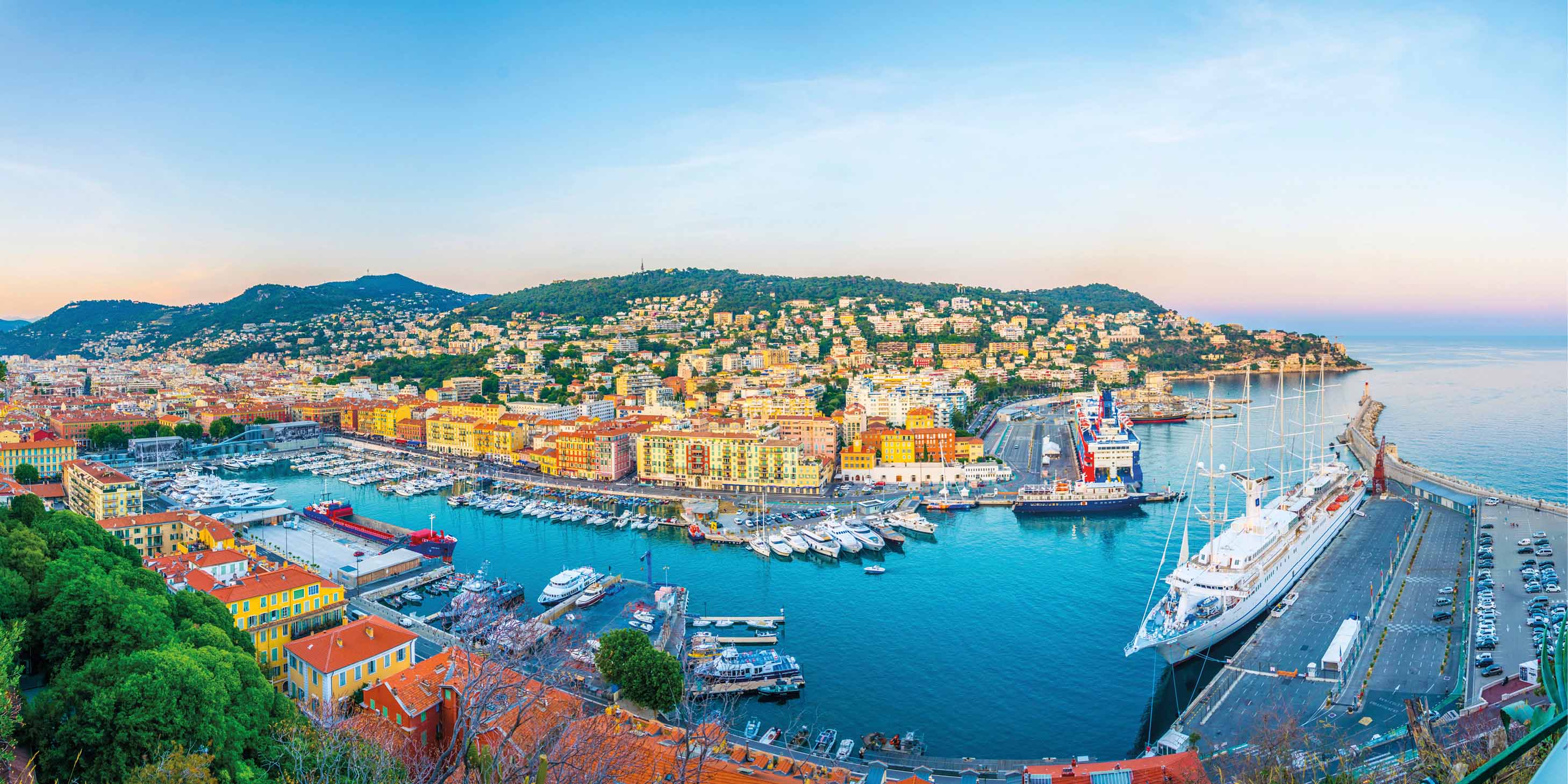 A view of Nice, France with colourful buildings and the Mediterranean Sea in the background.
