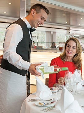Couple enjoying a meal and glass of white wine on board a luxury river ship