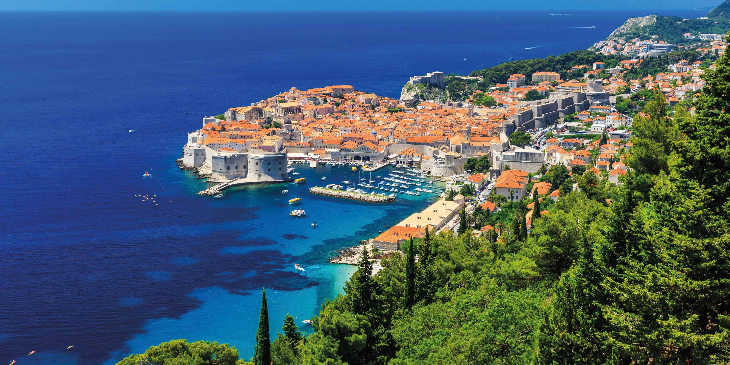 The coast of Dubrovnik, Croatia on a sunny day, the blue sky and blue sea in contrast to the green land above