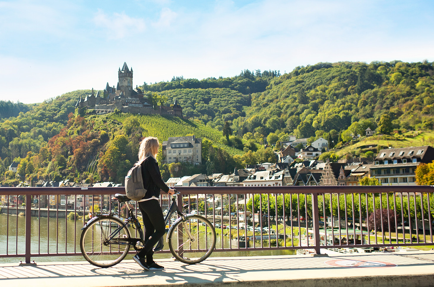 Guests enjoying a bike tour in Cochem, Germany, looking up at the castle at surrounding green trees