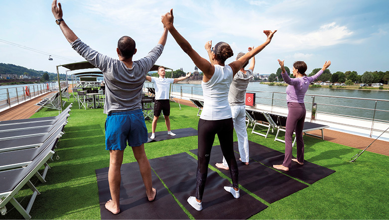 Guests taking part in a yoga session on the Sun Deck of a luxury river ship in Europe