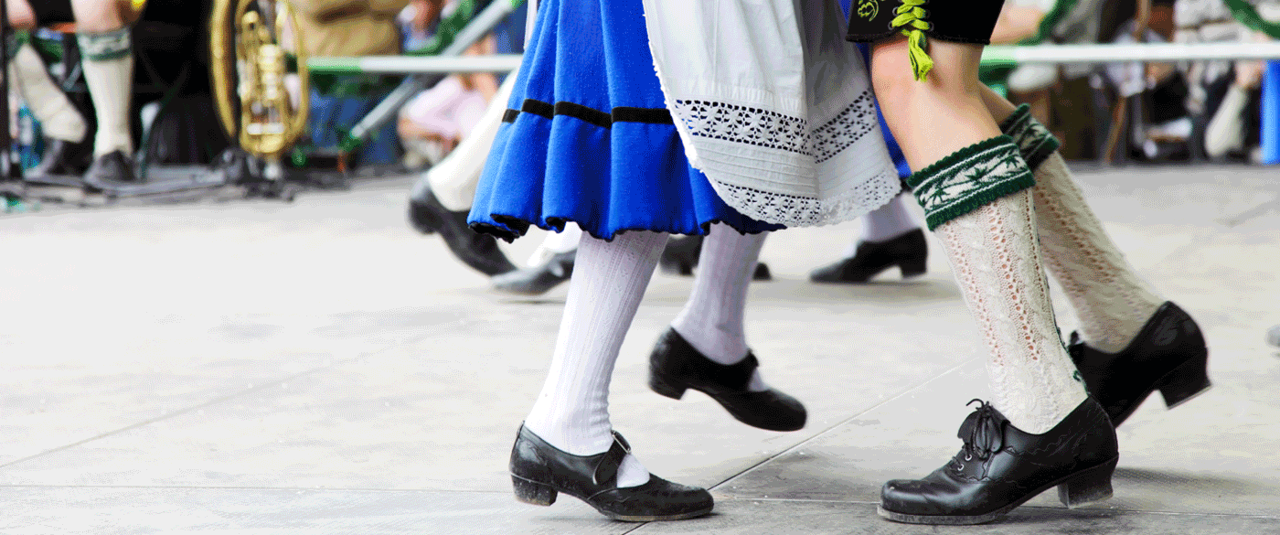 Bavarian couple dancing wearing traditional clothes