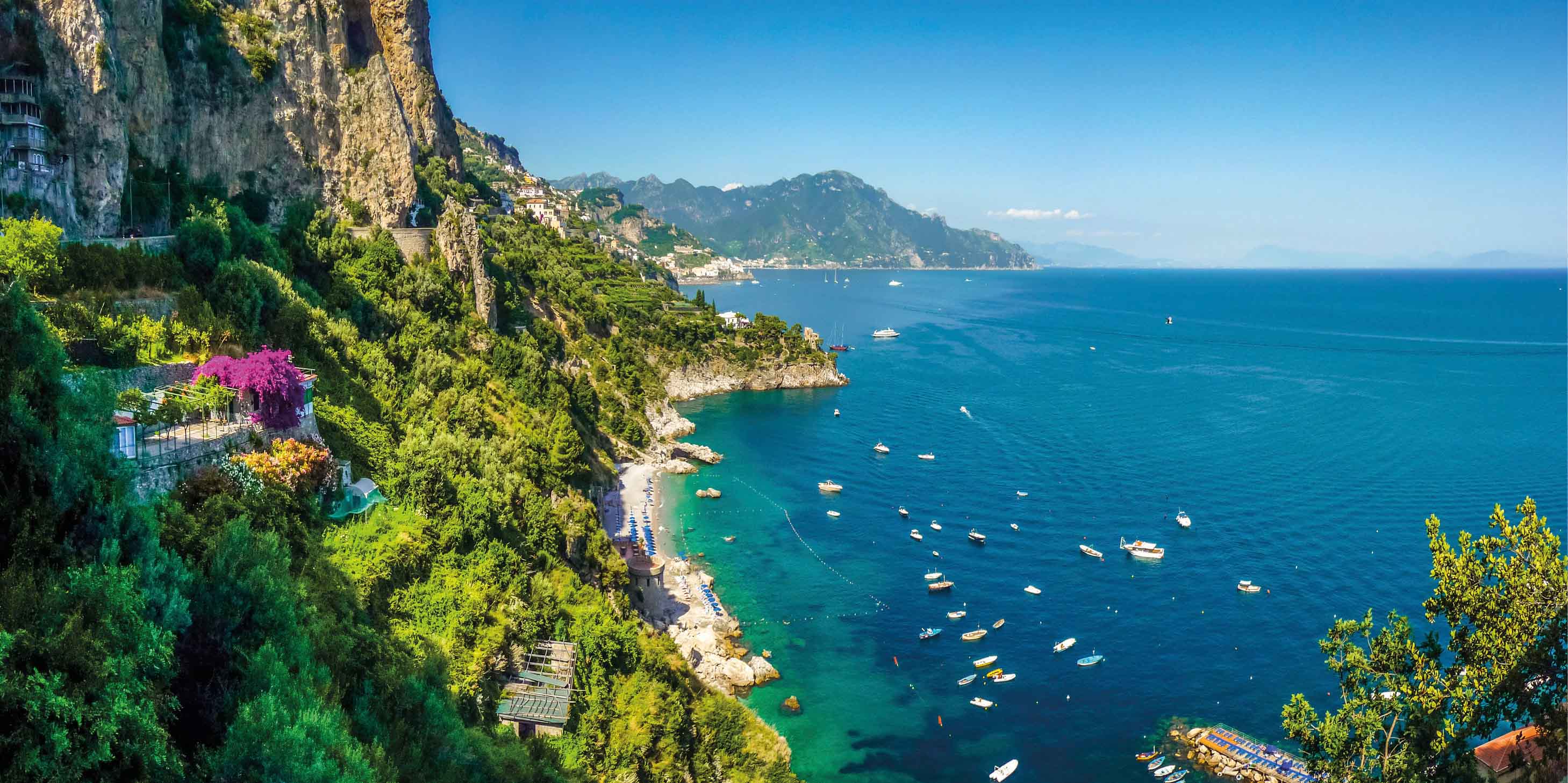 Amalfi Coast, Gulf of Salerno, with blue sea, blue sky, and green hills and cliff faces